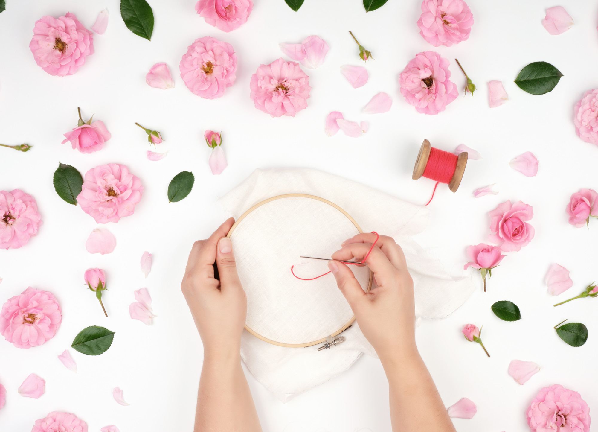 Artist stitching floral pattern in workshop